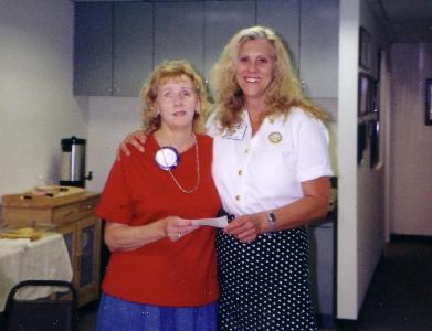 Beth Anderson (right), Burbank Sunrise Rotary Club President, presents Nancy Burns with a check to help fund a new Braille embosser.
